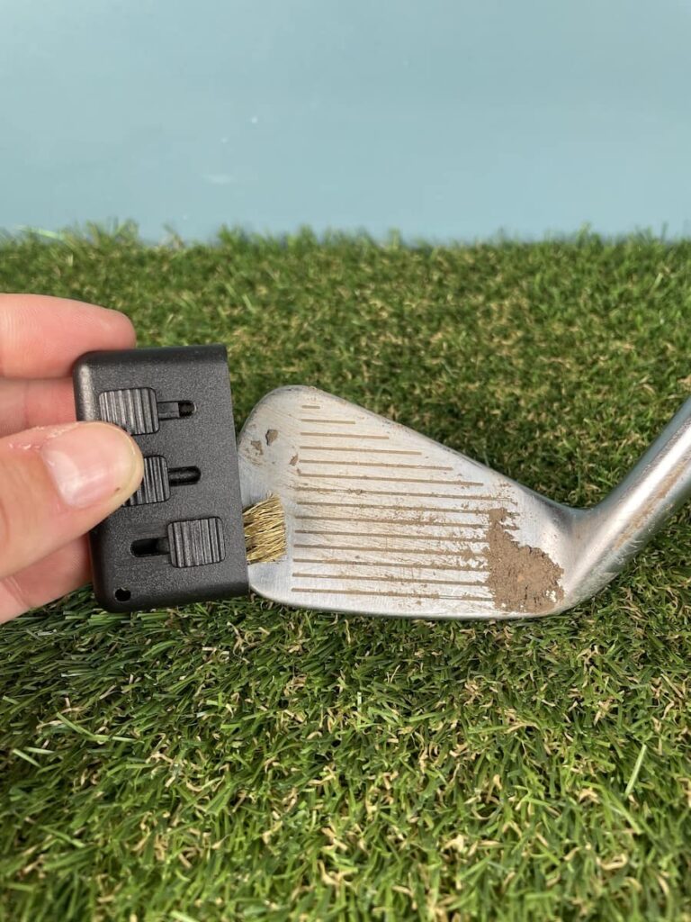Cleaning excess dirt on club face before cleaning with Club Clean