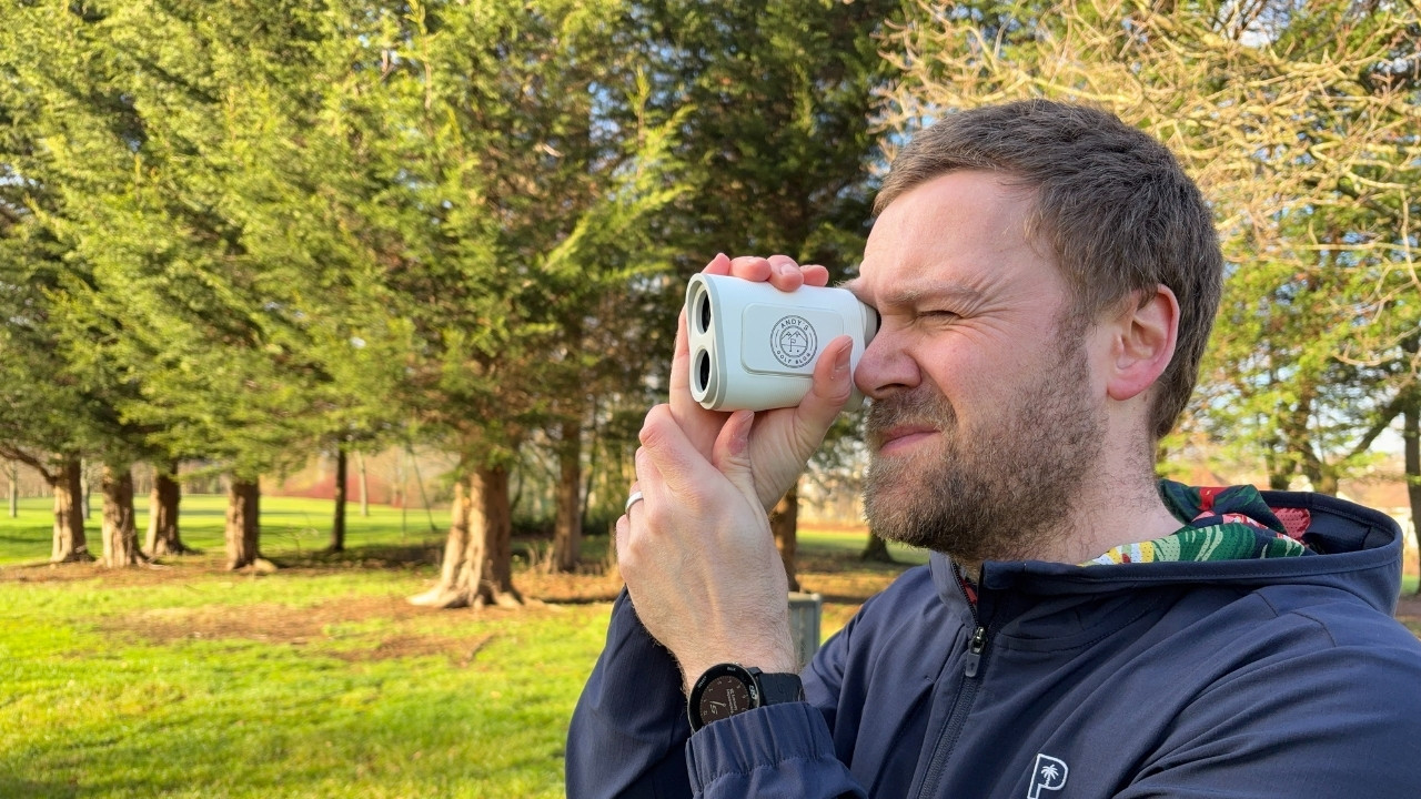 Andy looking through the Shot Scope PRO X laser rangefinder on the golf course.