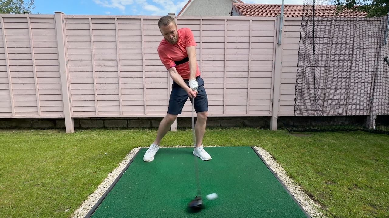 Andy improving angle of attack with driver at impact using the TRS Slider swing training aid.