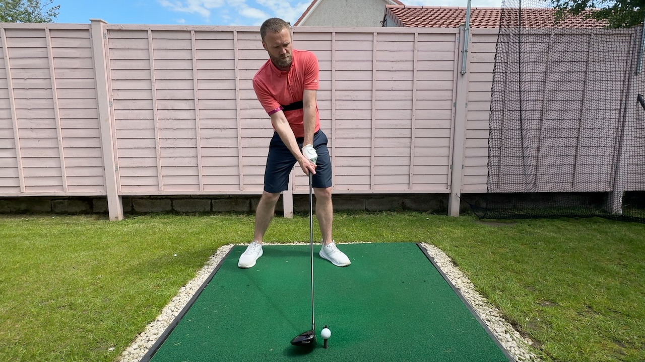 Andy setting up to hit a driver whilst wearing the TRS Slider swing training aid.