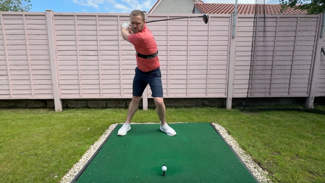 Andy with a shortened backswing with the driver using the TRS Slider swing training aid.