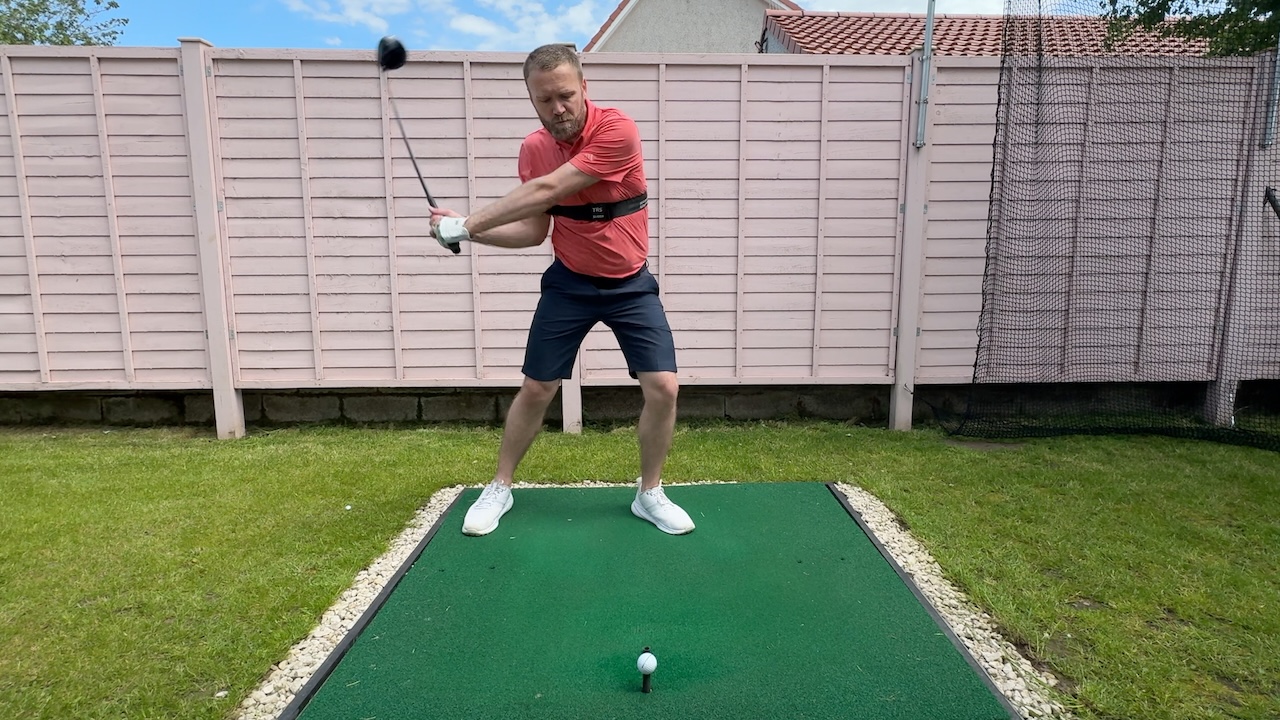 Andy hitting a driver whilst wearing the TRS Slider swing training aid.