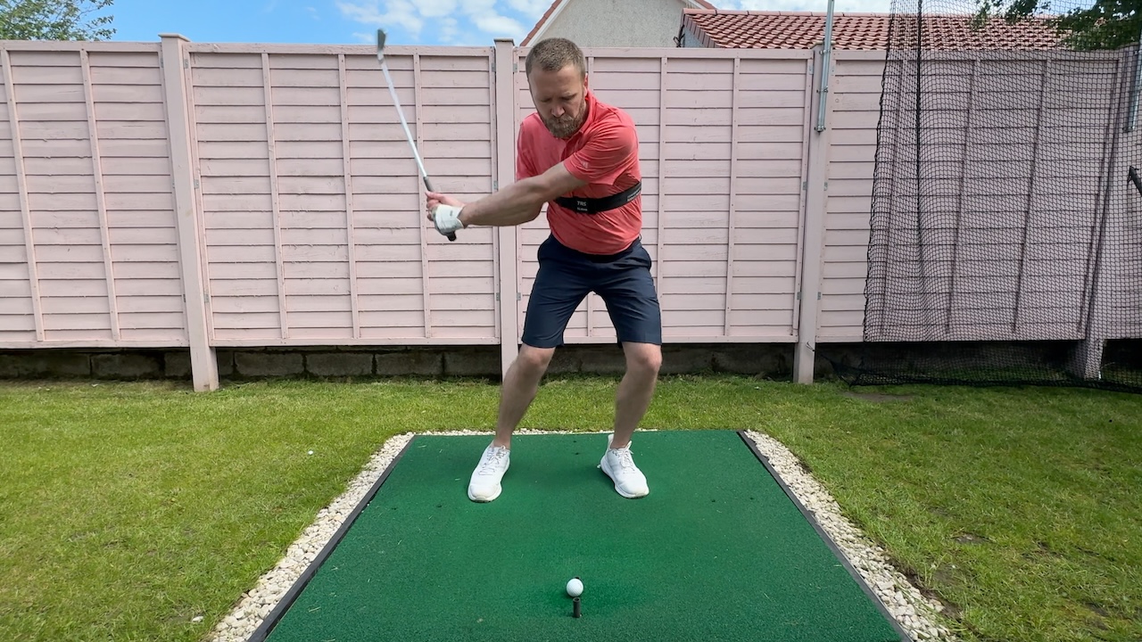 Andy hitting an iron whilst wearing the TRS Slider swing training aid.