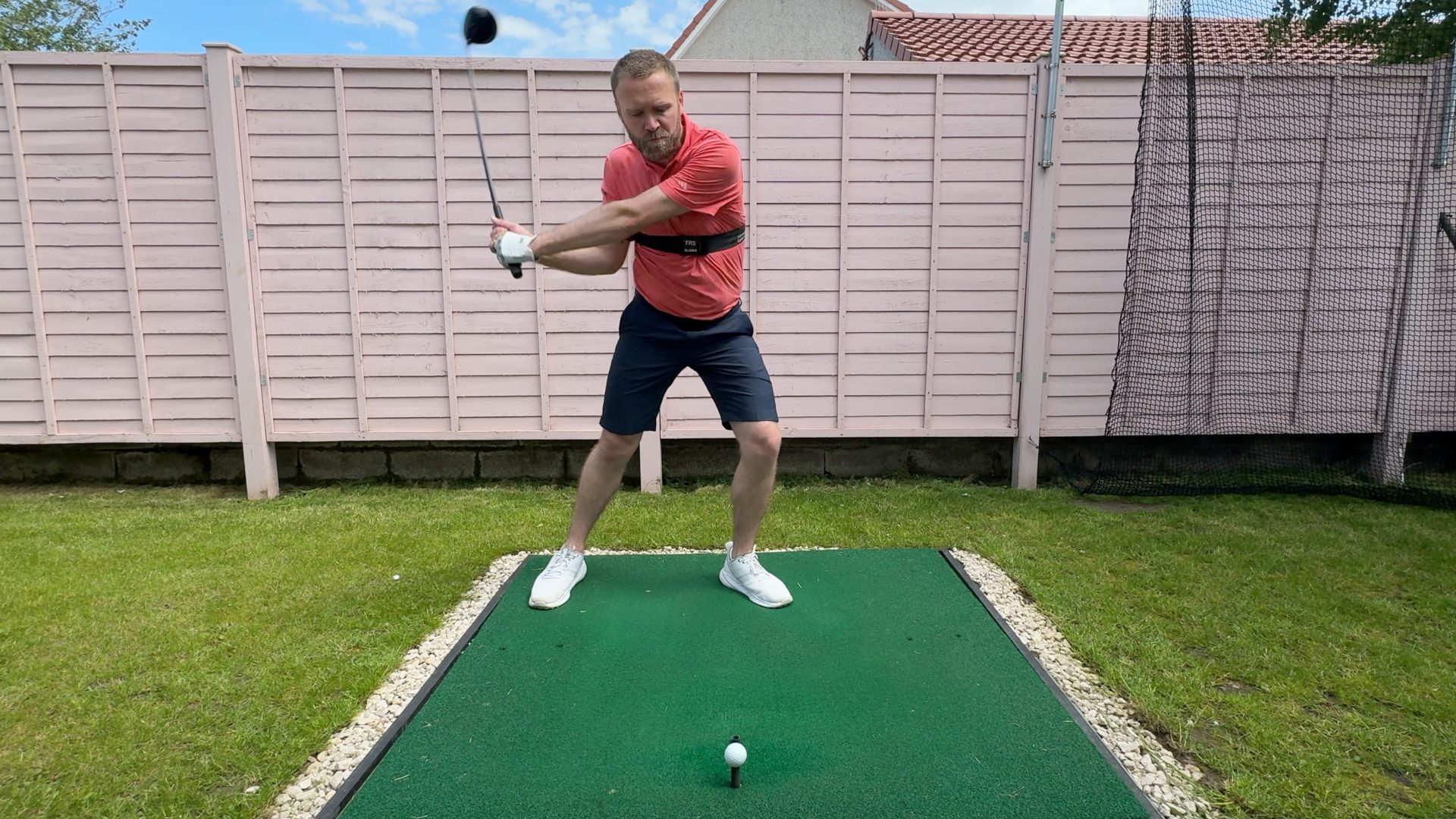Trail elbow tucked in on the downswing with driver whilst using the TRS Slider swing training aid.