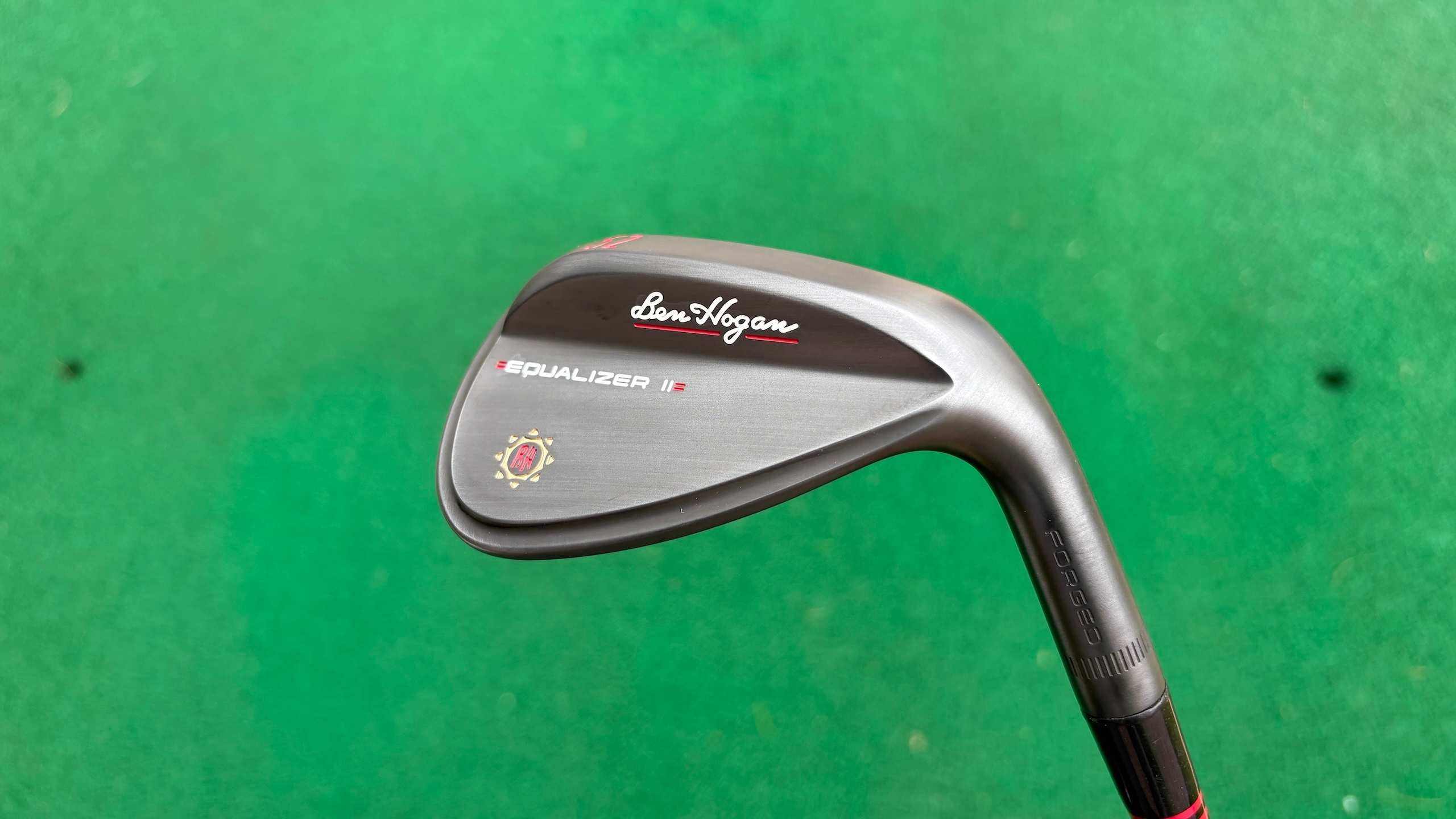 Ben Hogan Equalizer II wedge head positioned over green driving range mat