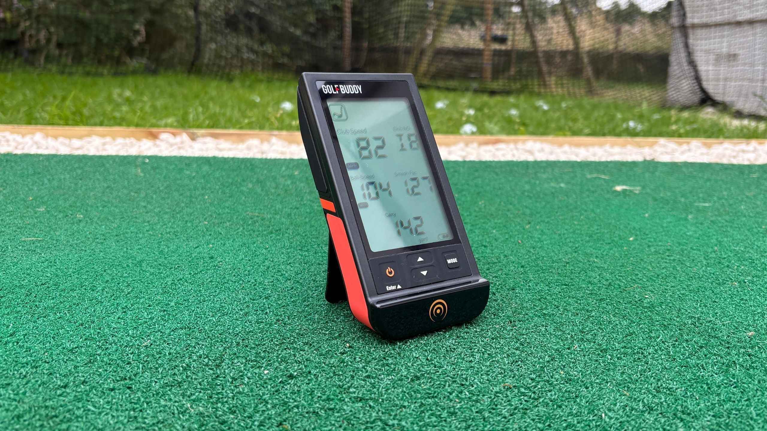 GolfBuddy Shot Mate launch monitor sitting on driving range mat