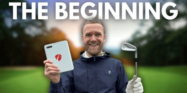 A man standing in front of a golf course holding a golf club and the FlightScope Mevo Gen 2 launch monitor.